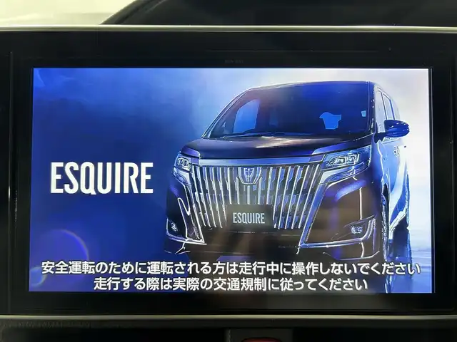 トヨタ エスクァイア ハイブリッド Gi プレミアムパッケージ 佐賀県 2017(平29)年 6.3万km ブラック 純正10型ナビ/ＡＭ/ＦＭ/CD/DVD/Bluetooth/フルセグTV/純正12.1インチ後席モニター/バックカメラ/クルーズコントロール/前後ドライブレコーダー/デジタルインナーミラー/衝突被害軽減システム/レーンアシスト/ハーフレザーシート/シートヒーター/ステアリングヒーター/ETC/LEDヘッドライト/フォグランプ/オートエアコン/盗難防止装置/横滑り防止装置/車線逸脱警報/オートライト/スマートキー/プッシュスタート/純正フロアマット/純正15インチアルミホイール	/ステアリングスイッチ/電動格納ミラー/コーナーセンサー
