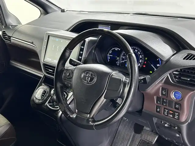 トヨタ エスクァイア ハイブリッド Gi プレミアムパッケージ 佐賀県 2017(平29)年 6.3万km ブラック 純正10型ナビ/ＡＭ/ＦＭ/CD/DVD/Bluetooth/フルセグTV/純正12.1インチ後席モニター/バックカメラ/クルーズコントロール/前後ドライブレコーダー/デジタルインナーミラー/衝突被害軽減システム/レーンアシスト/ハーフレザーシート/シートヒーター/ステアリングヒーター/ETC/LEDヘッドライト/フォグランプ/オートエアコン/盗難防止装置/横滑り防止装置/車線逸脱警報/オートライト/スマートキー/プッシュスタート/純正フロアマット/純正15インチアルミホイール	/ステアリングスイッチ/電動格納ミラー/コーナーセンサー