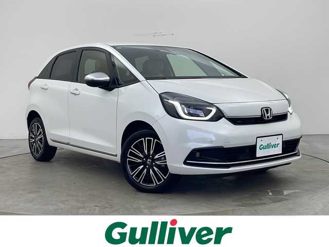 ホンダ フィット リュクス 秋田県 2024(令6)年 0.5万km プラチナホワイトパール 4WD/純正SDナビ　/フルセグTV/Bluetooth/CD/DVD/ホンダセンシング　/レーダークルーズコントロール　/レーンキープアシスト　/横滑り防止装置/前後クリアランスソナー/誤発進抑制/バックカメラ　/寒冷地仕様/ワイパーデアイサー/前席シートヒーター/ステアリングヒーター/ＬＥＤヘッドライト/フォグランプ/本革シート　/置くだけ充電/ビルトインＥＴＣ　/電動パーキング/純正ドライブレコーダー　/純正アルミホイール/純正フロアマット