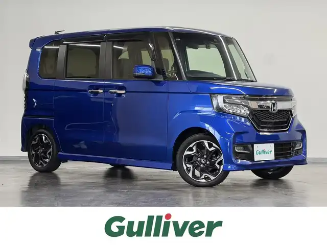 ホンダ Ｎ ＢＯＸ カスタム G L ターボ ホンダセンシング 三重県 2018(平30)年 4.5万km ブリリアントスポーティブルーメタリック2トーン ガソリン・ターボ/FF/MTモード付インパネCVT/純正 7インチナビ VXM-184VFi/（CD/DVD/FM/AM/TV/iPod/SD/USB/Bluetooth/AUX）/バックカメラ/両側パワースライドドア/ドライブレコーダー 前後/ビルトイン ETC/Honda SENSING/・衝突軽減ブレーキ［CMBS］/・車線維持支援システム［LKAS］/・路外逸脱抑制機能/・アダプティブクルーズコントロール［ACC］/・先行車発進お知らせ機能/・標識認識機能/装備/・ハーフレザーシート/・オートライト/・LEDヘッドランプ/・LEDフロントフォグランプ/・パドルシフト/・オートエアコン（マイナスイオン発生機能付）/・ステアリングスイッチ/・2.5A 急速充電対応 USB充電ジャックx2/・電動格納ドアミラー/・リヤドアロールサンシェード/・プッシュスタート/・純正15inAW/・スマートキーx2/・保/取/ナビ取/など