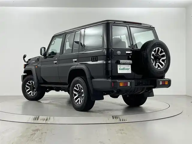 トヨタ ランドクルーザー AX 埼玉県 2024(令6)年 1.1万km アティチュードブラックマイカ パートタイム4WD/トヨタセーフティーセンス/社外ナビ/（フルセグTV/CD/DVD/Bluetooth）/バックカメラ/クルーズコントロール/ヒルスタートアシストコントロール/ダウンヒルアシストコントロール/前後ドライブレコーダーTZ-DR210/オートLEDヘッドライト/背面タイヤ/純正１６インチアルミホイール/デュアルモードオートマチックロッキングハブ/電動デフロック