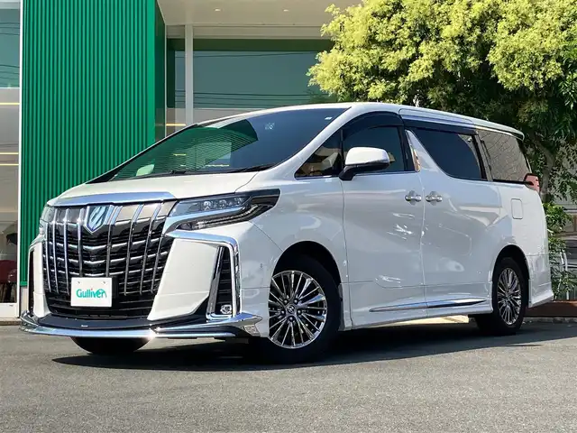 トヨタ アルファードハイブリット エグゼクティブ ラウンジ S 静岡県 2022(令4)年 2.9万km ホワイトパールクリスタルシャイン エンジンスタートボタン/パワーステアリング/パワーウィンドウ/4WD/100V充電/パーキングアシスト/アイドリングスストップ/レンタカーアップ/スマートキー/スペアキー１本/Wオートエアコン/クルーズコントロール（追従走行：有）/全方位カメラ/ビルトインETC2.0/フリップダウンモニター/USB入力端子/純正9インチSDナビ(CD/BT/フルセグ)/三列シート/サンルーフ/オットマン/電動リアゲート/ドライブレコーダー前後/純正フロアマット/D席N席パワーシート/レザーシート/1~2列目シートヒーター/1~2列目エアシート/両側パワースライドドア/モデリスタエアロ（フロント/サイド/リア）/純正17インチアルミホイール/ABS/横滑り防止装置/コーナーセンサー前後/レーンキープアシスト/オートライト/オートマチックハイビーム/三眼LEDヘッドライト/JBL/BSM(ブラインドスポットモニター)/デジタルインナーミラー/ステアリングヒーター/Wプラスサイドエアバック/衝突軽減システム/カーテンエアバック