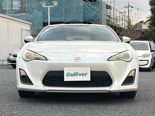 トヨタ ８６ GT 東京都 2012(平24)年 8.9万km サテンホワイトパール 純正ナビ（NHZN-W61G）/・Bluetooth/TV/CD/DVD/USB/バックカメラ/ドライブレコーダー（VREC-DZ300）/横滑り防止装置/盗難防止装置/17インチ純正アルミホイール/電動格納ミラー/rosso modello製マフラー/KUHL RACING スワンネックGTウィング/社外テールランプ/オートエアコン/オートライト/パドルシフト