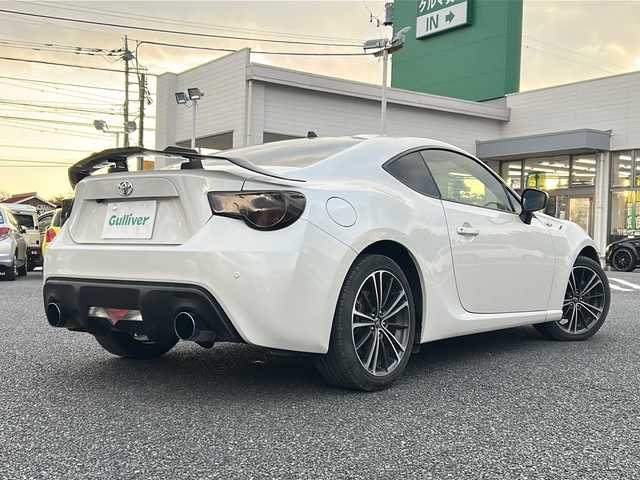 トヨタ ８６ GT 東京都 2012(平24)年 8.9万km サテンホワイトパール 純正ナビ（NHZN-W61G）/・Bluetooth/TV/CD/DVD/USB/バックカメラ/ドライブレコーダー（VREC-DZ300）/横滑り防止装置/盗難防止装置/17インチ純正アルミホイール/電動格納ミラー/rosso modello製マフラー/KUHL RACING スワンネックGTウィング/社外テールランプ/オートエアコン/オートライト/パドルシフト