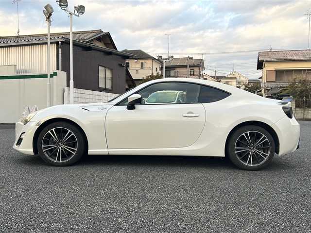 トヨタ ８６ GT 東京都 2012(平24)年 8.9万km サテンホワイトパール 純正ナビ（NHZN-W61G）/・Bluetooth/TV/CD/DVD/USB/バックカメラ/ドライブレコーダー（VREC-DZ300）/横滑り防止装置/盗難防止装置/17インチ純正アルミホイール/電動格納ミラー/rosso modello製マフラー/KUHL RACING スワンネックGTウィング/社外テールランプ/オートエアコン/オートライト/パドルシフト