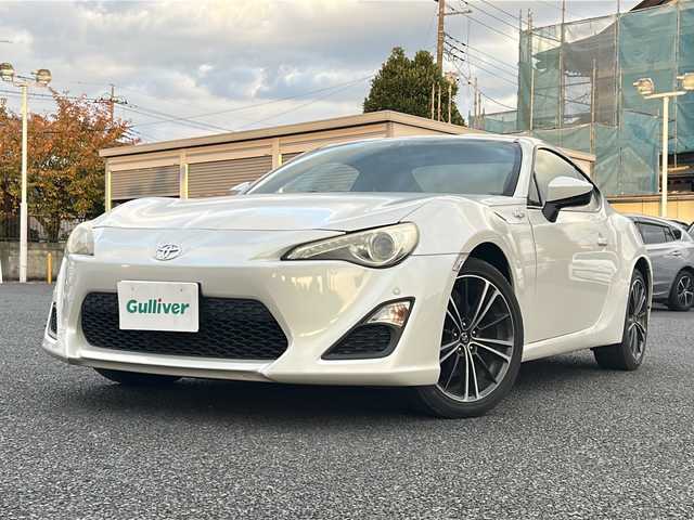 トヨタ ８６ GT 東京都 2012(平24)年 8.9万km サテンホワイトパール 純正ナビ（NHZN-W61G）/・Bluetooth/TV/CD/DVD/USB/バックカメラ/ドライブレコーダー（VREC-DZ300）/横滑り防止装置/盗難防止装置/17インチ純正アルミホイール/電動格納ミラー/rosso modello製マフラー/KUHL RACING スワンネックGTウィング/社外テールランプ/オートエアコン/オートライト/パドルシフト
