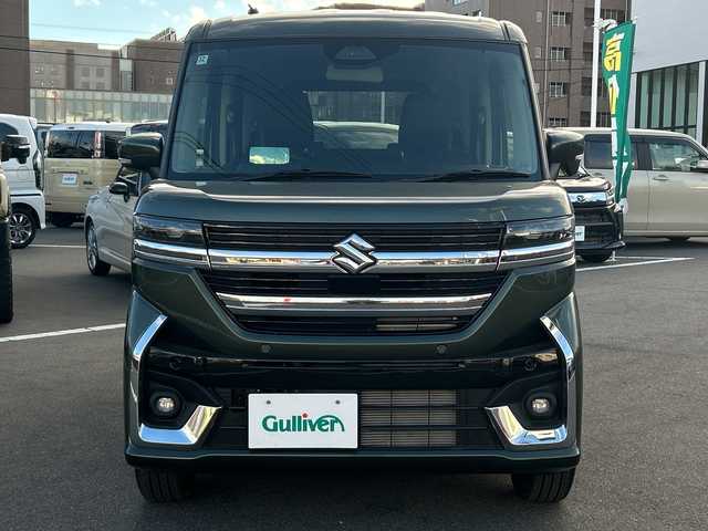 スズキ スペーシア カスタム HYBRID XS 長野県 2024(令6)年 0.4万km クールカーキPM 禁煙車/社外8インチナビ（CD/DVD/フルセグTV/Bluetooth）/セーフティサポート/・デュアルセンサーブレーキサポート/・誤発進抑制機能/・車線逸脱警報機能/・ふらつき警報機能/・先行車発進お知らせ機能/・ハイビームアシスト/・後退時ブレーキサポート/・後方誤発進抑制機能/・リアパーキングセンサー/・アダプティブクルーズコントロール/・標識認識機能/・ヘッドアップディスプレイ/バックカメラ/両側パワースライドドア/前席シートヒーター/ハーフレザーシート/ステアリングヒーター/革巻きステアリング/ステアリングスイッチ/LEDヘッドライト/フォグランプ/オートライト/電動パーキングブレーキ/ブレーキホールド/アイドリングストップ/スマートキー/Pスタート/電動格納ミラー/純正15インチAW/純正フロアマット