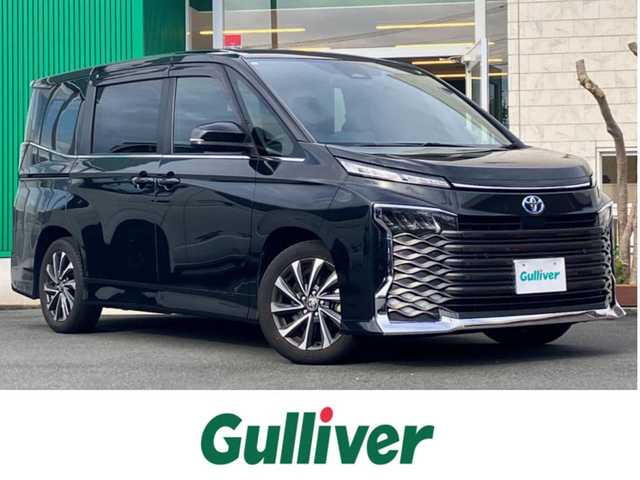 トヨタ ヴォクシー ハイブリッド S－Z 静岡県 2023(令5)年 5.9万km グリッターブラックガラスフレーク 純正10.5インチナビ(CD/DVD/BT/フルセグ)/14インチ後席モニター(V14T-R72R)/純正ETC2.0/ドライブレコーダー前後+車内/エンジンスタートボタン/パワーステアリング/パワーウィンドウ/アイドリングストップ/100V充電/スマートキー/Wオートエアコン/レーダークルーズコントロール/USB入力端子/バックカメラ/三列シート/純正フロアマット/ハーフレザーシート/D席N席シートヒーター/両側パワースライドドア/純正17インチアルミホイール/ABS/横滑り防止装置/コーナーセンサー前後/レーンキープアシスト/オートライト/オートマチックハイビーム/LEDヘッドライト/W+サイドエアバック/衝突軽減システム/HDMI接続