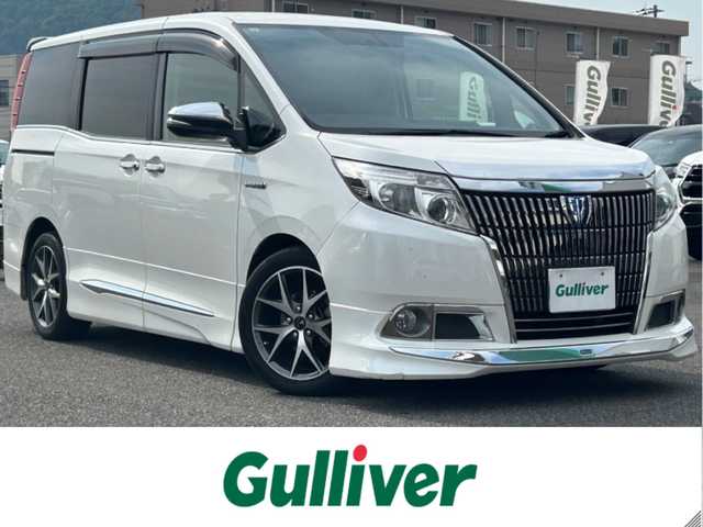 トヨタ エスクァイア ハイブリッド Xi 広島県 2015(平27)年 10.8万km ホワイトパールクリスタルシャイン モデリスタエアロ/モデリスタ17インチアルミホイール/片側パワースライドドア/アルパインビックX11インチナビ/　（DVD/CD/SD/BT/フルセグTV）/アルパインフリップダウンモニター/バックカメラ/ステアリングリモコン/ビルトインETC/前方ドライブレコーダー/前席ヒートシーター/オートリトラミラー/LEDヘッドライト/オートライト/フォグランプ/純正フロアマット/スペアキー/横滑り防止装置/盗難防止装置/保証書/取扱説明書