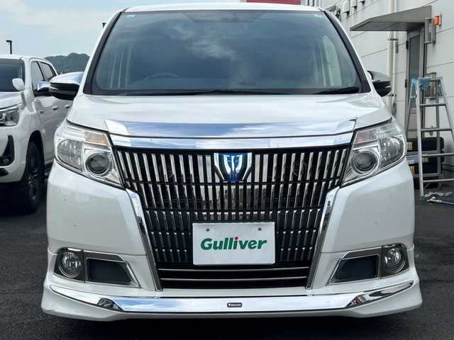 トヨタ エスクァイア ハイブリッド Xi 広島県 2015(平27)年 10.8万km ホワイトパールクリスタルシャイン モデリスタエアロ/モデリスタ17インチアルミホイール/片側パワースライドドア/アルパインビックX11インチナビ/　（DVD/CD/SD/BT/フルセグTV）/アルパインフリップダウンモニター/バックカメラ/ステアリングリモコン/ビルトインETC/前方ドライブレコーダー/前席ヒートシーター/オートリトラミラー/LEDヘッドライト/オートライト/フォグランプ/純正フロアマット/スペアキー/横滑り防止装置/盗難防止装置/保証書/取扱説明書
