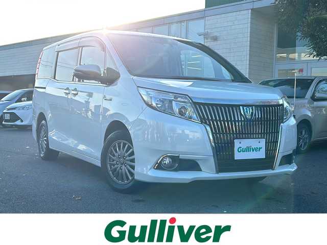 トヨタ エスクァイア ハイブリッド Gi 鳥取県 2016(平28)年 6.2万km ホワイトパールクリスタルシャイン ワンオーナー/純正SDナビ(NSZT-Y66T)/フルセグTV/AM/FM、CD/DVD/Bluetooth/ETC/ドライブレコーダー(前後)/LEDヘッドランプ（ハイ・ロービーム、オートレベリング機能付）/LEDフロントフォグランプ（標準装備）/15インチアルミホイール（標準装備）/合成皮革シート表皮（昇温降温抑制機能付）/快適温熱シート（運転席・助手席/ステアリングホイール＆シフトノブ（本革巻き、黒木目調加飾）/助手席シートバックテーブル（カップホルダー2個付、メッキガーニッシュ付）/デュアルエアコン/S-VSC（横滑り防止装置）/EBD付ABS（アンチロックブレーキシステム）/オートマチックハイビーム/両側パワースライドドア/シートヒーター/スタッドレスタイヤ4本積み込み