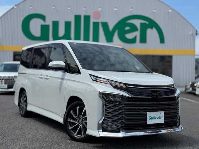 トヨタ ヴォクシー ハイブリッド S－Z 滋賀県 2023(令5)年 1.4万km ホワイトパールクリスタルシャイン 純正ディスプレイオーディオPlus コネクテッィドナビ対応/　フルセグ Bluetooth CD DVD  /トヨタチームメイト/快適利便パッケージ/ドライビングサポートパッケージ/ハンズフリーデュアルパワースライドドア/ブラインドスポットモニター/ユニバーサルステップ/パワーバッックドア/ナノイー/ステアリングヒーター/デジタルインナーミラー/カラーヘッドアップディスプレイ/パノラミックビューモニター/パーキングサポートブレーキ/Toyota Safety Sense /プリクラッシュセーフティー/緊急時操舵支援/フロントクロストラフィックアラート/レーンチェンジアシスト/レーントレーシングアシスト/レーンディパーチャーアラート/レーダークルーズコントロール/オートマチックハイビーム/ロードサインアシスト/ドライバー異常時対応システム/プロアクティブドライビングアシスト/発進遅れ告知機能/ドライブレコーダー前後/両側パワースライドドア/ETC2.0/AC100V/純正17インチアルミ/純正フロアマット/スマートキー×2/プッシュスタート/