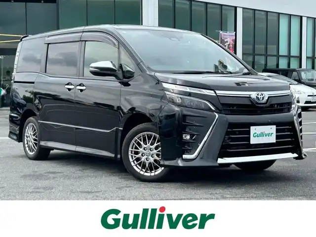 トヨタ ヴォクシー ハイブリッド ZS 煌Ⅲ 奈良県 2021(令3)年 3.1万km ブラック 純正メモリーナビ（NSZT-W68T）/(AM/FM/CD/DVD/BT/SD/フルセグTV)/ハーフレザーシート/シートヒーター/バックカメラ/ビルトインETC/両側パワースライドドア/クリアランスソナー/トヨタセーフティセンス/・プリクラッシュセーフティ/・レーントレーシングアシスト/・オートマチックハイビーム/クルーズコントロール/革巻きステアリング/ステアリングスイッチ/純正フロアマット/純正ドアバイザー/電格ウインカーミラー/プッシュスタート/スペアキー