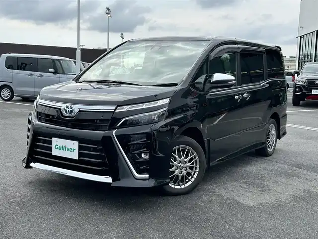 トヨタ ヴォクシー ハイブリッド ZS 煌Ⅲ 奈良県 2021(令3)年 3.1万km ブラック 純正メモリーナビ（NSZT-W68T）/(AM/FM/CD/DVD/BT/SD/フルセグTV)/ハーフレザーシート/シートヒーター/バックカメラ/ビルトインETC/両側パワースライドドア/クリアランスソナー/トヨタセーフティセンス/・プリクラッシュセーフティ/・レーントレーシングアシスト/・オートマチックハイビーム/クルーズコントロール/革巻きステアリング/ステアリングスイッチ/純正フロアマット/純正ドアバイザー/電格ウインカーミラー/プッシュスタート/スペアキー