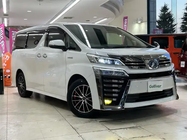 トヨタ ヴェルファイア ハイブリット ZR 東京都 2019(平31)年 4.2万km ホワイトパールクリスタルシャイン 純正ナビ/(NSZN-Z68T)/(CD/DVD/フルセグ/Bluetooth/HDMI)/バックカメラ/コーナーセンサー/レザーシート/前席シートヒーター/前席シートクーラー/前席パワーシート/運転席メモリーシート/助手席+2列目席オットマン/電動パーキング/LDW/プリクラッシュセーフティ/PKSB/レーダークルーズコントロール/スマートキー/パワードサブウーファー/(carroozzeria)/pivot/(3-drivePRO)/スペアキー×1/プッシュスタート/オートライト/三眼LEDライト/オートハイビーム/フロントフォグランプ/ETC/純正フロアマット/ISOFIX/ドラレコ/革巻きステアリング/ステアリングスイッチ/プライバシーガラス/ドアバイザー/電動格納ウィンカーミラー/社外17インチアルミホイール/W+カーテンSRS+ABS/横滑り防止装置/取扱説明書
