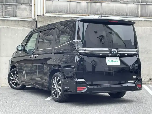 トヨタ ヴォクシー ハイブリッド S－Z 愛知県 2022(令4)年 4.7万km アティチュードブラックマイカ ワンオーナー/快適利便パッケージHigh/・ハンズフリーデュアルパワースライドドア/・パワーバックドア/・ナノイーX/・ステアリングヒーター/・キャプテンシート/ドライビングサポートパッケージ/・デジタルインナーミラー/・ヘッドアップディスプレイ/BSM・SEA・FCTA・LCA・トヨタチームメイト 寒冷地仕様/トヨタセーフティセンス/・プリクラッシュセーフティーシステム/・レーントレーシングアシスト/・レーダークルーズコントロール/・アダプティブハイビーム/・ロードサインアシスト/・発進遅れ告知機能/アドバンストドライブ/10.5インチディスプレイオーディオ+ナビ/フルセグTV+CD＋DVDデッキ/HDMI/14型有機EL後席ディスプレイ/ETC2.0/三眼LEDヘッドライト+AHB/オートライト/フォグランプ/スペアタイヤ/TRD GRスポーツサドバイザー/AC100Vコンセント/純正フロアマット/保証書/取扱説明書