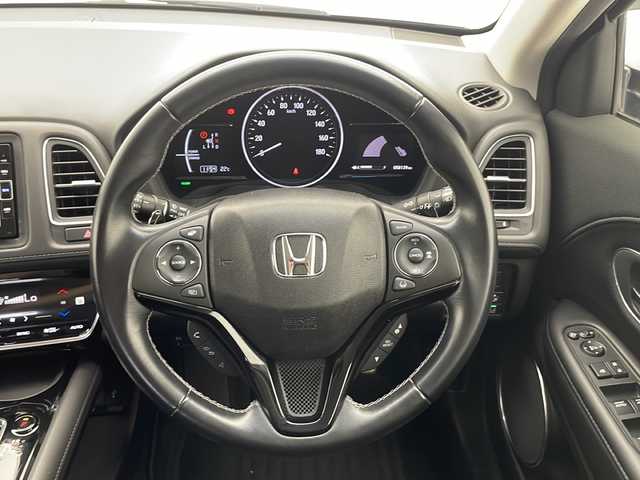 ホンダ ヴェゼル ハイブリッド Z ホンダセンシング 千葉県 2018(平30)年 5.9万km ルーセブラックM ホンダセンシング/衝突被害軽減装置/レーンキープアシスト/レーダークルーズコントロール/先行車発進お知らせ/路外逸脱抑制システム/横滑り防止装置/リアクティブフォースペダル/標識認識/ディーラー純正ナビ/　CD DVD BT フルセグTV/バックカメラ/ホールド機能付き電子パーキングブレーキ/前後ドライブレコーダー/ビルトインETC/ハーフレザーシート/シートヒーター/トノカバー/LEDヘッドライト/オートライト/フォグランプ/電動格納ウィンカーミラー/ドアバイザー/純正フロアマット/PWオールオート/ルーフレール/革巻きステアリング/ステアリングスイッチ/パドルシフト/プッシュスタート/スマートキー