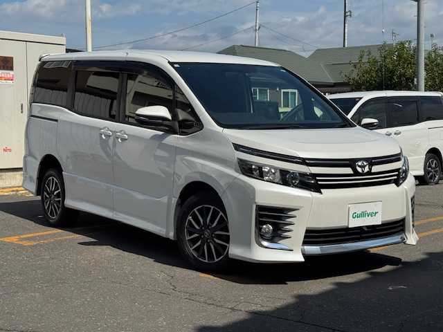 トヨタ ヴォクシー ZS 道東・釧路十勝 2014(平26)年 7.6万km ホワイトパールクリスタルシャイン 4WD/7人乗り/寒冷地仕様/純正9インチメモリーナビ/  (DVD/CD/フルセグTV/Bluetooth)/バックカメラ/純正フリップダウンモニター/両側パワースライドドア/LEDヘッドライト/フォグライト/革巻きステアリング/ステアリングリモコン/アイドリングストップ/ドライブレコーダー/ウィンカーミラー/電動格納ミラー/フロントワイパーデアイサー/ビルトインETC/運転席シートリフター/純正ドアバイザー/純正フロアマット/純正キーレス一体型エンジンスターター/ディーラー記録簿 R1/2/3/4/5/スマートキー/エンジンプッシュスタート/スペアキー/取扱説明書/保証書/ナビ取説/純正16インチアルミホイール