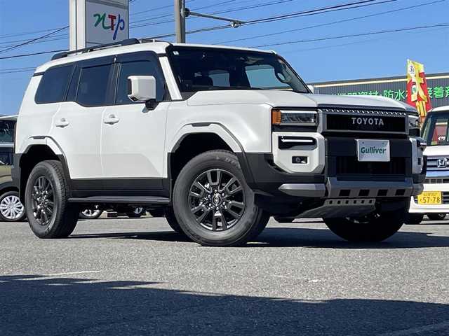 トヨタ ランドクルーザー ２５０ VX 愛知県 2024(令6)年 0.1千km プラチナホワイトパールマイカ /禁煙車//ワンオーナー//サンルーフ//モデリスタパッケージ//モデリスタオーバーフェンダー//モデリスタリアスポイラー//モデリスタリヤバンパーステップガード//モデリスタシグネチャーイルミブレード//モデリスタLEDスマートフットライト//12.3インチディスプレイオーディオ//フルセグTV/BT/USB/Miracast//パノラミックビューモニター//黒革シート//エアシート//シートヒーター//パワーシート//ETC2.0//デジタルインナーミラー//パワーバックドア//ルーフレール//サイドステップ//MTモード付AT//純正ドライブレコーダー//PCS/LDA/BSM/PDA/RSA/ACC/RCTA/RCD/クリアランスソナー/安心降車アシスト/後方車両接近検知//オートリトラウィンカーミラー//LEDオートライト//オートハイビーム//ヘッドライトウォッシャー//純正フロアマット//純正ドアバイザー//純正トノカバー//純正ラゲージソフトトレイ//プロジェクションカーテンイルミ//ドアエッジプロテクター//革巻きステアリング//ステアリングスイッチ//ステアリングヒーター//エアコンドリンクホルダー//GPSレーダー探知機//スペアスマートキー//新車時保証書//取扱説明書