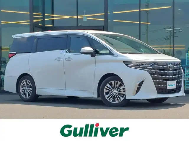 トヨタ アルファードハイブリット Z 東京都 2023(令5)年 1.6万km プラチナホワイトパールマイカ 13.2型有機EL後席ディスプレイ/純正14型メモリナビ/（FM/AM/BT/フルセグTV）/全方位バックカメラ/合皮シート/前席＋二席目シートベンチレーション/前席＋二席目シートヒーター/前席＋二席目パワーシート/ステアリングヒーター/置くだけ充電/デジタルインナーミラー/ETC2.0/電動リアゲート/トヨタセーフティセンス/・プリクラッシュセーフティ/・レーンキープアシスト/・ブラインドスポットモニター/・ヘッドアップディスプレイ/・クリアランスソナー/・パーキングサポートブレーキ/・ロードサインアシスト/・レーダークルーズコントロール/・アダクティブハイビームシステム/・両側パワースライドドア/・純正18インチAW/・純正LEDヘッドライト/・純正フロアマット