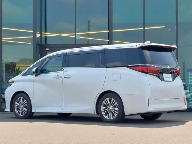 トヨタ アルファードハイブリット Z 東京都 2023(令5)年 1.6万km プラチナホワイトパールマイカ 13.2型有機EL後席ディスプレイ/純正14型メモリナビ/（FM/AM/BT/フルセグTV）/全方位バックカメラ/合皮シート/前席＋二席目シートベンチレーション/前席＋二席目シートヒーター/前席＋二席目パワーシート/ステアリングヒーター/置くだけ充電/デジタルインナーミラー/ETC2.0/電動リアゲート/トヨタセーフティセンス/・プリクラッシュセーフティ/・レーンキープアシスト/・ブラインドスポットモニター/・ヘッドアップディスプレイ/・クリアランスソナー/・パーキングサポートブレーキ/・ロードサインアシスト/・レーダークルーズコントロール/・アダクティブハイビームシステム/・両側パワースライドドア/・純正18インチAW/・純正LEDヘッドライト/・純正フロアマット