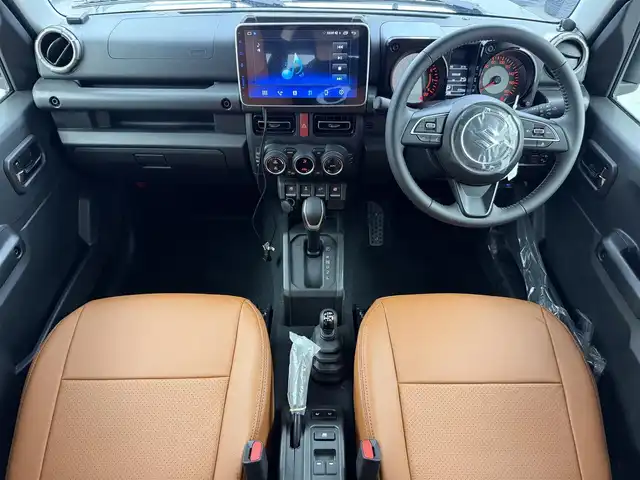 スズキ ジムニー ノマド FC 愛知県 2025(令7)年 0.1万km ブルーイッシュブラックパール3 10インチディスプレイオーディオ/ヒッチメンバー/ルーフキャリア/茶レザーシートカバー/背面タイヤ/ETC/４ＷＤ/デュアルブレーキサポート/レーダークルーズコントロール/シートヒーター（D+N)/ミラーヒーター/パーキングソナー/オートライト/社外16インチＡＷ/革巻きステアリング/ダウンヒルアシストコントロール/LEDヘッドライト/スマートキー/プッシュスタート/横滑り防止装置