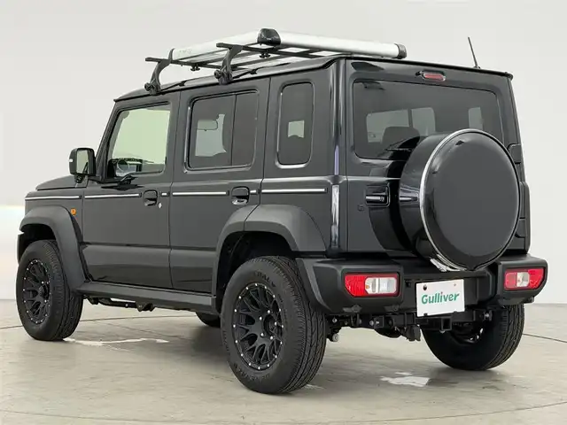 スズキ ジムニー ノマド FC 愛知県 2025(令7)年 0.1万km ブルーイッシュブラックパール3 10インチディスプレイオーディオ/ヒッチメンバー/ルーフキャリア/茶レザーシートカバー/背面タイヤ/ETC/４ＷＤ/デュアルブレーキサポート/レーダークルーズコントロール/シートヒーター（D+N)/ミラーヒーター/パーキングソナー/オートライト/社外16インチＡＷ/革巻きステアリング/ダウンヒルアシストコントロール/LEDヘッドライト/スマートキー/プッシュスタート/横滑り防止装置
