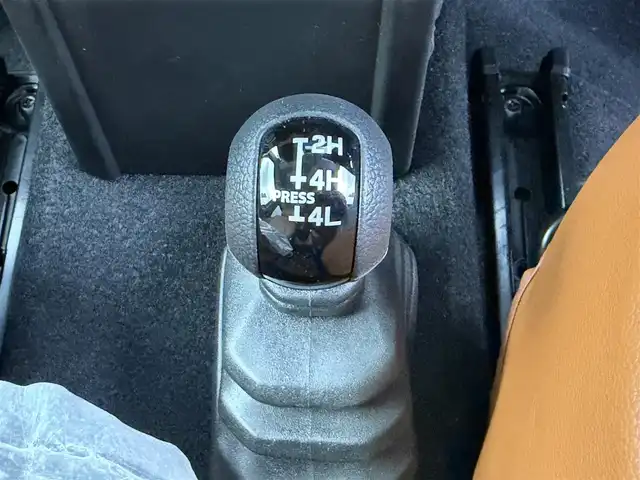スズキ ジムニー ノマド FC 愛知県 2025(令7)年 0.1万km ブルーイッシュブラックパール3 10インチディスプレイオーディオ/ヒッチメンバー/ルーフキャリア/茶レザーシートカバー/背面タイヤ/ETC/４ＷＤ/デュアルブレーキサポート/レーダークルーズコントロール/シートヒーター（D+N)/ミラーヒーター/パーキングソナー/オートライト/社外16インチＡＷ/革巻きステアリング/ダウンヒルアシストコントロール/LEDヘッドライト/スマートキー/プッシュスタート/横滑り防止装置