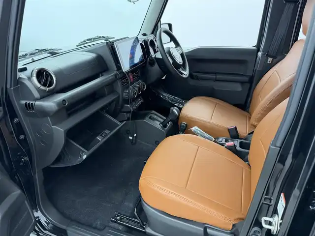 スズキ ジムニー ノマド FC 愛知県 2025(令7)年 0.1万km ブルーイッシュブラックパール3 10インチディスプレイオーディオ/ヒッチメンバー/ルーフキャリア/茶レザーシートカバー/背面タイヤ/ETC/４ＷＤ/デュアルブレーキサポート/レーダークルーズコントロール/シートヒーター（D+N)/ミラーヒーター/パーキングソナー/オートライト/社外16インチＡＷ/革巻きステアリング/ダウンヒルアシストコントロール/LEDヘッドライト/スマートキー/プッシュスタート/横滑り防止装置