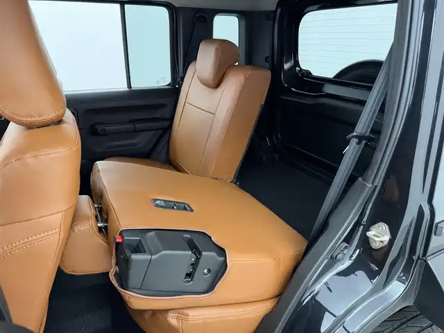 スズキ ジムニー ノマド FC 愛知県 2025(令7)年 0.1万km ブルーイッシュブラックパール3 10インチディスプレイオーディオ/ヒッチメンバー/ルーフキャリア/茶レザーシートカバー/背面タイヤ/ETC/４ＷＤ/デュアルブレーキサポート/レーダークルーズコントロール/シートヒーター（D+N)/ミラーヒーター/パーキングソナー/オートライト/社外16インチＡＷ/革巻きステアリング/ダウンヒルアシストコントロール/LEDヘッドライト/スマートキー/プッシュスタート/横滑り防止装置