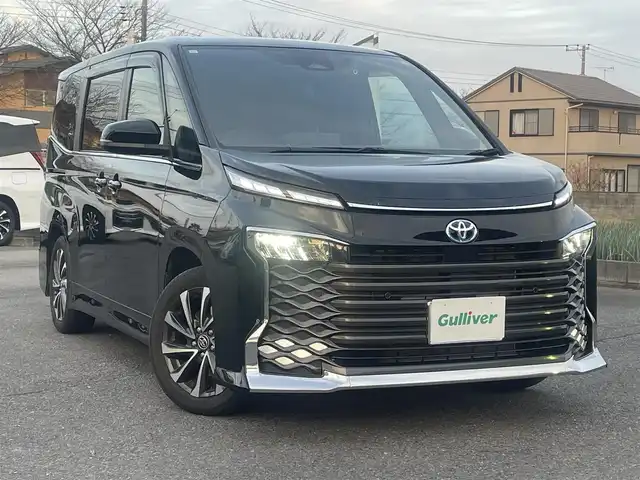 トヨタ ヴォクシー ハイブリッド S－Z 群馬県 2023(令5)年 2.4万km アティチュードブラックマイカ ワンオーナー/純正メモリナビ、地デジ、Bluetooth、CD/バックカメラ/ウインカーミラー/プリクラッシュセーフティ/ブラインドスポットモニター/レーダークルーズコントロール/革巻きステア/前席シートヒーター/ハーフレザーシート/純正フリップダウンモニター/両側パワースライドドア/社外ドライブレコーダー（前後録画）/LEDヘッドライト/ビルトインETC２．０/クリアランスソナー（前後）/オートステップ/AC100V電源/ミラーキャスト/整備手帳、取説