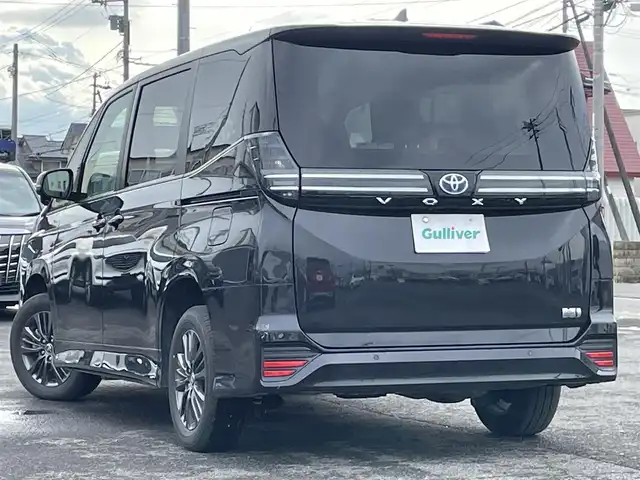 トヨタ ヴォクシー ハイブリッド S－G 道央・札幌 2025(令7)年 1.1万km グリッターブラックガラスフレーク ４WD/寒冷地仕様/純正ディスプレイオーディオ（ナビ付）/AM/FM/BT/トヨタセーフティセンス/プリクラッシュセーフティ/横滑り防止装置/レーダークルーズコントロール/レーンキープアシスト/パーキングアシスト/プロアクティブドライビングアシスト/パーキングサポートブレーキ/ロードサインアシスト/クリアランスソナー/バックカメラ/ビルトインETC2.0/EVMODE/DRIVEMODE切替/ワイパーデアイサー/片側パワースライドドア/革巻きステアリング/ステアリングリモコン/電動パーキング/ブレーキホールド/プッシュスタート/スマートキー/LEDヘッドライト/オートライト/オートハイビーム/ヘッドライトレベライザー/電動格納ミラー/ウィンカーミラー/純正フロアマット/レンタカー登録