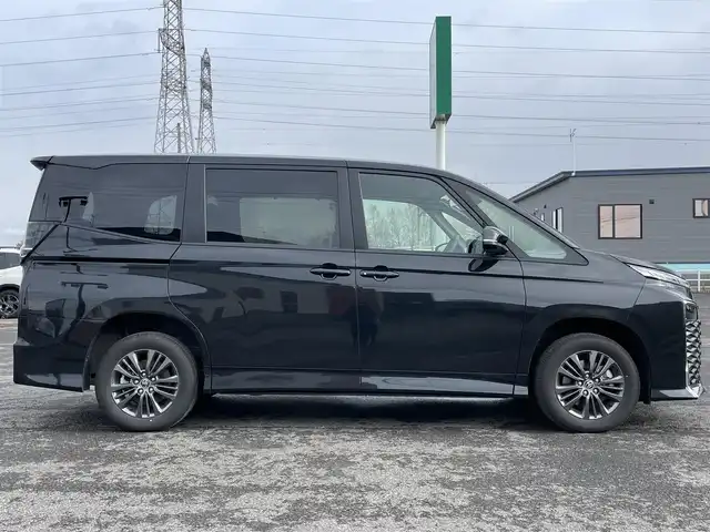 トヨタ ヴォクシー ハイブリッド S－G 道央・札幌 2025(令7)年 1.1万km グリッターブラックガラスフレーク ４WD/寒冷地仕様/純正ディスプレイオーディオ（ナビ付）/AM/FM/BT/トヨタセーフティセンス/プリクラッシュセーフティ/横滑り防止装置/レーダークルーズコントロール/レーンキープアシスト/パーキングアシスト/プロアクティブドライビングアシスト/パーキングサポートブレーキ/ロードサインアシスト/クリアランスソナー/バックカメラ/ビルトインETC2.0/EVMODE/DRIVEMODE切替/ワイパーデアイサー/片側パワースライドドア/革巻きステアリング/ステアリングリモコン/電動パーキング/ブレーキホールド/プッシュスタート/スマートキー/LEDヘッドライト/オートライト/オートハイビーム/ヘッドライトレベライザー/電動格納ミラー/ウィンカーミラー/純正フロアマット/レンタカー登録