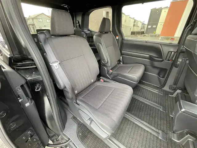 トヨタ ヴォクシー ハイブリッド S－G 道央・札幌 2025(令7)年 1.1万km グリッターブラックガラスフレーク ４WD/寒冷地仕様/純正ディスプレイオーディオ（ナビ付）/AM/FM/BT/トヨタセーフティセンス/プリクラッシュセーフティ/横滑り防止装置/レーダークルーズコントロール/レーンキープアシスト/パーキングアシスト/プロアクティブドライビングアシスト/パーキングサポートブレーキ/ロードサインアシスト/クリアランスソナー/バックカメラ/ビルトインETC2.0/EVMODE/DRIVEMODE切替/ワイパーデアイサー/片側パワースライドドア/革巻きステアリング/ステアリングリモコン/電動パーキング/ブレーキホールド/プッシュスタート/スマートキー/LEDヘッドライト/オートライト/オートハイビーム/ヘッドライトレベライザー/電動格納ミラー/ウィンカーミラー/純正フロアマット/レンタカー登録