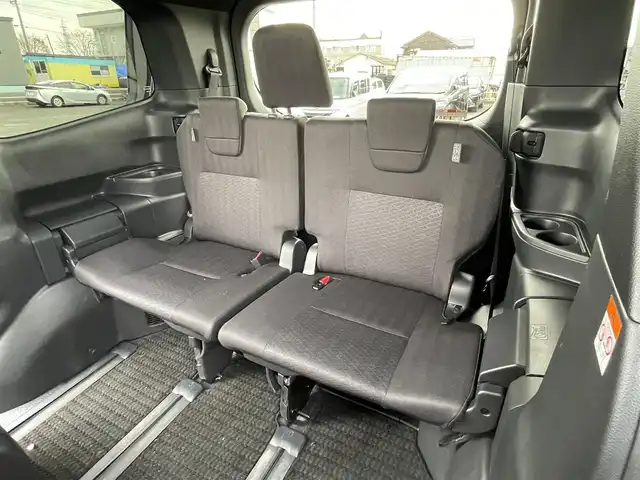 トヨタ ヴォクシー ハイブリッド S－G 道央・札幌 2025(令7)年 1.1万km グリッターブラックガラスフレーク ４WD/寒冷地仕様/純正ディスプレイオーディオ（ナビ付）/AM/FM/BT/トヨタセーフティセンス/プリクラッシュセーフティ/横滑り防止装置/レーダークルーズコントロール/レーンキープアシスト/パーキングアシスト/プロアクティブドライビングアシスト/パーキングサポートブレーキ/ロードサインアシスト/クリアランスソナー/バックカメラ/ビルトインETC2.0/EVMODE/DRIVEMODE切替/ワイパーデアイサー/片側パワースライドドア/革巻きステアリング/ステアリングリモコン/電動パーキング/ブレーキホールド/プッシュスタート/スマートキー/LEDヘッドライト/オートライト/オートハイビーム/ヘッドライトレベライザー/電動格納ミラー/ウィンカーミラー/純正フロアマット/レンタカー登録