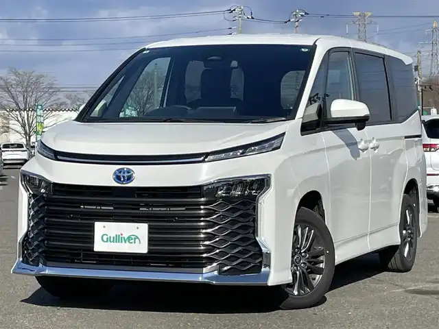 トヨタ ヴォクシー ハイブリッド S－G 道央・札幌 2025(令7)年 1.3万km ホワイトパールクリスタルシャイン ４WD/寒冷地仕様/純正ディスプレイオーディオ（ナビ付）/AM/FM/BT/トヨタセーフティセンス/プリクラッシュセーフティ/横滑り防止装置/レーダークルーズコントロール/レーンキープアシスト/クリアランスソナー/プロアクティブドライビングアシスト/パーキングサポートブレーキ/ロードサインアシスト/バックカメラ/ビルトインETC2.0/EVMODE/DRIVEMODE切替/ワイパーデアイサー/片側パワースライドドア/革巻きステアリング/ステアリングリモコン/プッシュスタート/スマートキー/LEDヘッドライト/オートライト/オートハイビーム/ヘッドライトレベライザー/電動格納ミラー/ウィンカーミラー/フロアマット/レンタカー登録