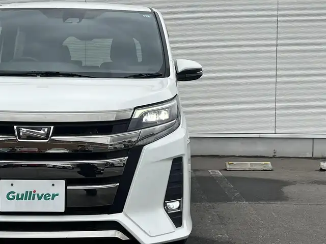 トヨタ ノア Si 秋田県 2017(平29)年 10.3万km ホワイトパールクリスタルシャイン 純正ナビ/衝突軽減システム/４WD/スマートキー/両側パワスラ/フルセグ/フルエアロ/バックカメラ/純正アルミ/ETC/アイドリングストップ/プッシュスタート/レーンキープアシスト/クルーズコントロール/MTモード付AT/ステアリングスイッチ/寒冷地仕様/純正フロアマット/純正ドアバイザー/フリップダウンモニター/パワーステアリング/パワーウィンドウ/オートライト/オートエアコン/電動格納ウィンカーミラー/横滑り防止