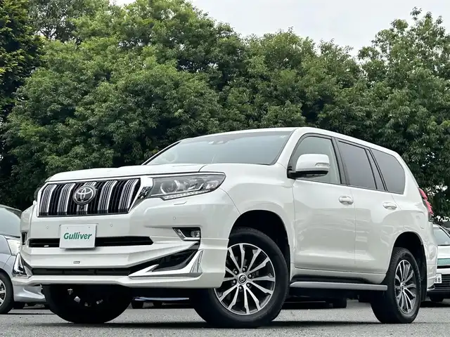 トヨタ ランドクルーザー プラド TX Lパッケージ 東京都 2019(平31)年 2.1万km ホワイトパールクリスタルシャイン ワンオーナー/メーカーオプションナビ（8インチ）/・Bluetoothオーディオ/USBオーディオ/・DVD/Blu-ray/フルセグTV/マルチテレインモニター/電動ムーンルーフ/純正19インチアルミホイール/クリアランスソナー&バックソナー/木目調・本革巻きステアリングホイール/Toyota Safety Sense/ビルトインETC2.0/取扱説明書/保証書/スペアキー1本