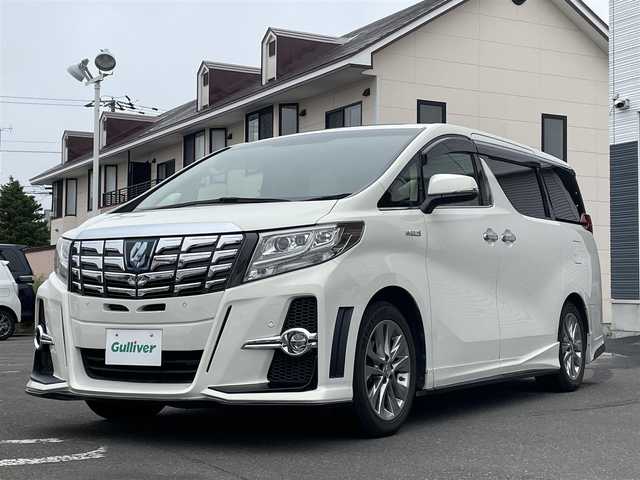 トヨタ アルファードハイブリット G 道央・札幌 2015(平27)年 7.8万km ラグジュアリーホワイトパールクリスタルシャインガラスフレーク 　4　W　D　/WALDフルエアロ/JBLプレミアムサウンド/サンルーフ/純正メーカーナビ/(AM/FM/CD/DVD/BT)/フルセグ(走行中視聴可能)/全方位モニター/パワーバックドア/両側パワースライドドア/純正フリップダウンモニター/前後ドライブレコーダー/コーナーセンサー/ステアリングスイッチ/プリクラッシュセーフティ/運転席パワーシート/オットマン/ETC/ドアバイザー/ウインカーミラー/自動防眩ミラー/オートブレーキホールド/オートライト/フォグランプ