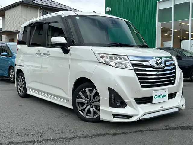 トヨタ ルーミー カスタムG－T 静岡県 2019(令1)年 4.4万km パール エンジンスタートボタン/パワーステアリング/パワーウィンドウ/アイドリングストップ/スマートキー/オートエアコン/クルーズコントロール/SDナビ（CD.DVD)/Bluetooth/SDミュージックサーバー/TV（フルセグ）/ETC/ウォークスルー/純正フロアマット/シートヒーター/両側パワースライドドア/エアロパーツ（モデリスタ）/純正アルミホイール/ABS/横滑り防止装置/コーナーセンサー前後/レーンキープアシスト/オートライト/オートマチックハイビーム/LEDライト/Wエアバッグ/衝突軽減システム