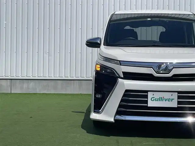トヨタ ヴォクシー ZS 煌 香川県 2018(平30)年 3万km ホワイトパールクリスタルシャイン 登録時走行距離：29833km/純正SDナビゲーション/→フルセグTV/→CD/DVD再生/バックカメラ/フリップダウンモニター/ビルトインETC/クルーズコントロール/両側パワースライドドア/エアロ（サイド・リア）/LEDオートライト/フォグランプ/オートハイビーム/純正16インチアルミホイール/スマートキー/スペアキー