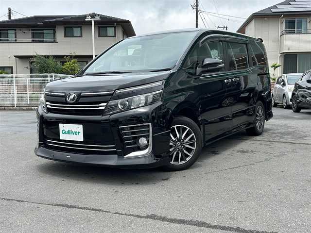 トヨタ ヴォクシー ZS 静岡県 2014(平26)年 4.8万km ブラック エンジンスタートボタン/パワーステアリング/パワーウィンドウ/アイドリングストップ/スマートキー/Bluetooth/後席用モニター/SDナビ（NSZT-W626)/3列シート/純正フロアマット/布シート/両側パワースライドドア/エアロパーツ（モデリスタ）/純正アルミホイール/ABS/横滑り防止装置/オートライト/LED/Wエアバッグ