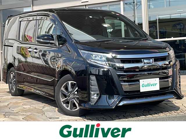 トヨタ ノア Si ダブルバイビー 静岡県 2018(平30)年 6.2万km ブラック 【安全装備】/トヨタセーフティセンス/プリクラッシュセーフティ/（レーザーレーダー・単眼カメラ方式）/（自車車速約30km/hから80km/h間：ブレーキアシスト機能発動）/（自車車速約10km/hから80km/h間踏力無時：約30km/h減速）/レーンディパーチャーアラート/（作動車速50km/h以上時）/オートマチックハイビーム/（作動車速30km/h以上時）/先行車発進お知らせ機能/【主要装備】/純正１０インチナビ　/後席フリップダウンモニター　/ハーフレザーシート　/両側パワースライドドア　/ビルトインＥＴＣ　/オートライト　/アイドリングストップ　/ＬＥＤヘッドライト　/クルーズコントロール　/プッシュスタート/スマートキー/純正16インチアルミホイール