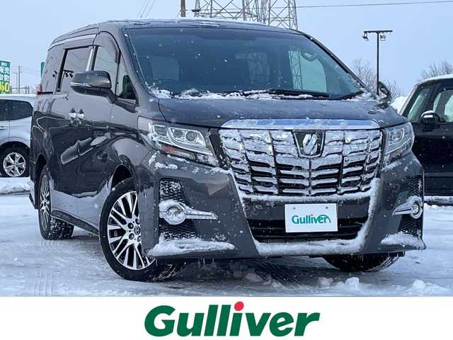トヨタ アルファード S Cパッケージ 道央・札幌 2015(平27)年 6.9万km グレーメタリック ４WD/JBLプレミアムサウンド/純正メモリーナビ/AM/FM/BT/SD/CD/フルセグ/純正フリップダウンモニター/トヨタセーフティセンス/衝突被害軽減ブレーキ/横滑り防止装置/レーダークルーズコントロール/レーンキープアシスト/パーキングアシスト/クリアランスソナー/バックカメラ/ビルトインETC/ドライブレコーダー/アイドリングストップ/ECOMODE/両側パワースライドドア/パワーバックドア/前席/2列目パワーシート/D席メモリーシート/N席/2列目オットマン/ハーフレザーシート/革巻きウッドコンビステアリング/ステアリングリモコン/ハンドルヒーター/AC100V/電動パーキング/ブレーキホールド/自動防眩ミラー/MTモード付AT/プッシュスタート/スマートキー/LEDヘッドライト/オートライト/フォグランプ/電動格納ミラー/ウィンカーミラー/純正フロアマット/ドアバイザー/スペアキー
