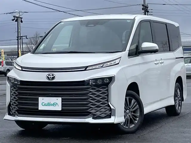 トヨタ ヴォクシー S－Z 道央・札幌 2023(令5)年 6.3万km ホワイトパールクリスタルシャイン ４WD/寒冷地仕様/純正ディスプレイオーディオ（ナビ付）/AM/FM/BT/トヨタセーフティセンス/プリクラッシュセーフティ/横滑り防止装置/レーダークルーズコントロール/レーンキープアシスト/クリアランスソナー/ブラインドスポットモニター/パーキングアシスト/PDA/RCTA/RCD/PKSB/SEA/RSA/AdvancedDrive/LCA/FCTA/パノラミックビューモニター/ビルトインETC/ドライブレコーダー/ECOMODE/ワイパーデアイサー/両側パワースライドドア/パワーバックドア/前席/２列目シートヒーター/ハーフレザーシート/革巻きステアリング/ステアリングリモコン/ハンドルヒーター/電動パーキング/ブレーキホールド/MTモード付AT/プッシュスタート/スマートキー/LEDヘッドライト/オートライト/オートハイビーム/電動格納ミラー/ウィンカーミラー/フロアマット/レンタカー登録