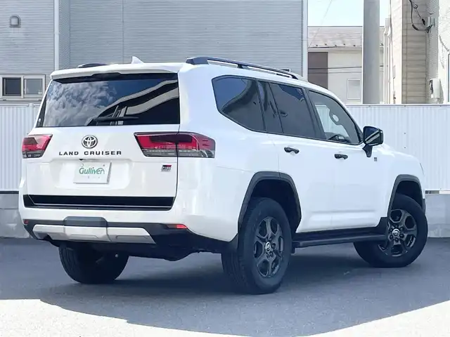 トヨタ ランドクルーザー GRスポーツ 栃木県 2024(令6)年 1.4万km プレシャスホワイトパール Toyota Safety Sense/・プリクラッシュセーフティ（歩行者［昼夜］・自転車運転者［昼］検知機能付衝突回避支援タイプ/ミリ波レーダー＋単眼カメラ方式）/・レーントレーシングアシスト［LTA］/・レーンディパーチャーアラート［LDA］/・ドライバー異常時対応システム/・レーダークルーズコントロール(全車速追従機能付)/・アダプティブハイビームアシスト［AHS］/・ロードサインアシスト［RSA］/・発進遅れ告知機能［TMN］/ブラインドスポットモニター［BSM］＋安心降車アシスト［SEA］＋後方車両接近告知＋周辺車両接近時サポート（通報提案機能）＋後方車両への接近警報＋セカンダリーコリジョンブレーキ（停車中後突対応）/パーキングサポートブレーキ/（前後方静止物・後方接近車両・後方歩行者）/パノラミックビューモニター（床下透過表示機能付）/マルチテレインモニター/電動デフロック/カラーヘッドアップディスプレイ/12.3インチHDディスプレイオーディオ（コネクティッドナビ対応）Plus/・TV（フルセグ）/・AppleCarPlay/AndroidAuto/・Bluetooth/JBLプレミアムサウンドシステム/（14スピーカー/12chオーディオアンプ）