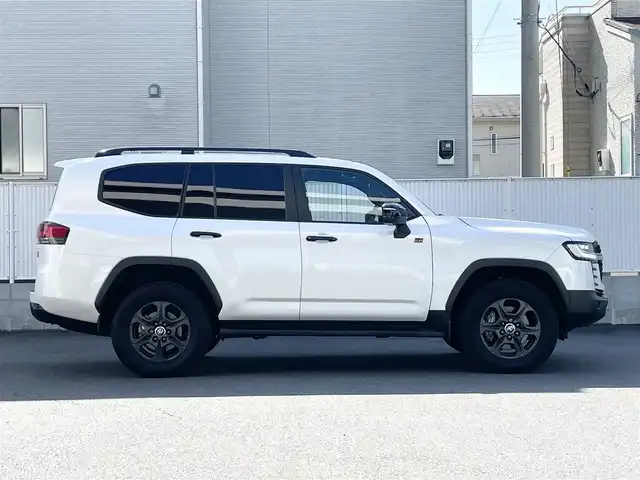 トヨタ ランドクルーザー GRスポーツ 栃木県 2024(令6)年 1.4万km プレシャスホワイトパール Toyota Safety Sense/・プリクラッシュセーフティ（歩行者［昼夜］・自転車運転者［昼］検知機能付衝突回避支援タイプ/ミリ波レーダー＋単眼カメラ方式）/・レーントレーシングアシスト［LTA］/・レーンディパーチャーアラート［LDA］/・ドライバー異常時対応システム/・レーダークルーズコントロール(全車速追従機能付)/・アダプティブハイビームアシスト［AHS］/・ロードサインアシスト［RSA］/・発進遅れ告知機能［TMN］/ブラインドスポットモニター［BSM］＋安心降車アシスト［SEA］＋後方車両接近告知＋周辺車両接近時サポート（通報提案機能）＋後方車両への接近警報＋セカンダリーコリジョンブレーキ（停車中後突対応）/パーキングサポートブレーキ/（前後方静止物・後方接近車両・後方歩行者）/パノラミックビューモニター（床下透過表示機能付）/マルチテレインモニター/電動デフロック/カラーヘッドアップディスプレイ/12.3インチHDディスプレイオーディオ（コネクティッドナビ対応）Plus/・TV（フルセグ）/・AppleCarPlay/AndroidAuto/・Bluetooth/JBLプレミアムサウンドシステム/（14スピーカー/12chオーディオアンプ）