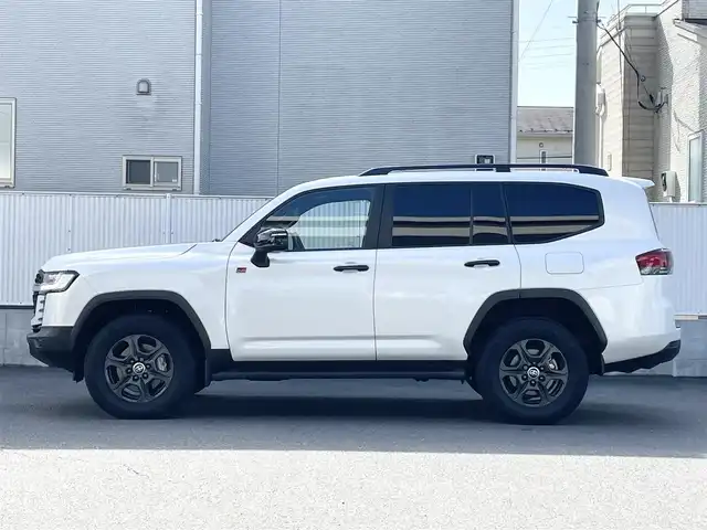 トヨタ ランドクルーザー GRスポーツ 栃木県 2024(令6)年 1.4万km プレシャスホワイトパール Toyota Safety Sense/・プリクラッシュセーフティ（歩行者［昼夜］・自転車運転者［昼］検知機能付衝突回避支援タイプ/ミリ波レーダー＋単眼カメラ方式）/・レーントレーシングアシスト［LTA］/・レーンディパーチャーアラート［LDA］/・ドライバー異常時対応システム/・レーダークルーズコントロール(全車速追従機能付)/・アダプティブハイビームアシスト［AHS］/・ロードサインアシスト［RSA］/・発進遅れ告知機能［TMN］/ブラインドスポットモニター［BSM］＋安心降車アシスト［SEA］＋後方車両接近告知＋周辺車両接近時サポート（通報提案機能）＋後方車両への接近警報＋セカンダリーコリジョンブレーキ（停車中後突対応）/パーキングサポートブレーキ/（前後方静止物・後方接近車両・後方歩行者）/パノラミックビューモニター（床下透過表示機能付）/マルチテレインモニター/電動デフロック/カラーヘッドアップディスプレイ/12.3インチHDディスプレイオーディオ（コネクティッドナビ対応）Plus/・TV（フルセグ）/・AppleCarPlay/AndroidAuto/・Bluetooth/JBLプレミアムサウンドシステム/（14スピーカー/12chオーディオアンプ）