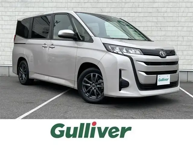 トヨタ ノア X 栃木県 2022(令4)年 2.3万km スティールブロンドM ワンオーナー/純正8型ディスプレイオーディオ/Bluetooth　CD　DVD　コネクティッドナビ対応/フルセグTV/バックカメラ/クリアランスソナー/・セーフティセンス/・プリクラッシュセーフティ/・レーンディパーチャーアラート/・オートマチックハイビーム/・ドライバー異常時対応システム/・プロアクティブドライビングアシスト/・発進遅れ告知機能/・レーントレーシングアシスト/・ロードサインアシスト/・パーキングサポートブレーキ/リフレクター式LEDヘッドランプ/ステアリングスイッチ/2列目アームレスト付キャプテンシート/折畳式サイドテーブル/レーベン16インチアルミホイール/オートライト/禁煙車/電子パーキングブレーキ/オートブレーキホールド
