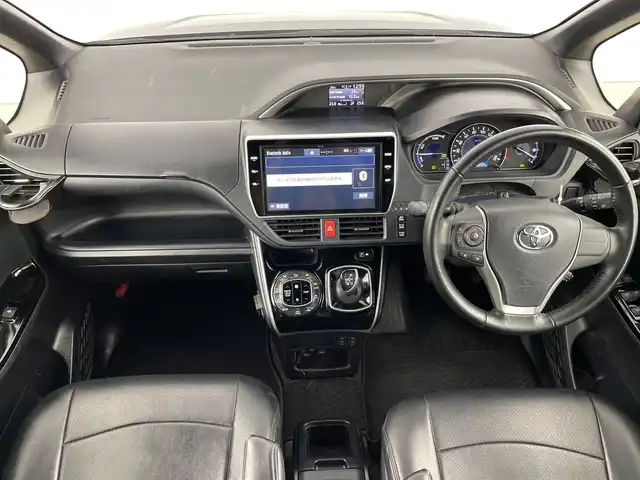 トヨタ ヴォクシー ハイブリッド ZS 煌Ⅱ 愛知県 2019(平31)年 6万km イナズマスパーキングブラックガラスフレーク 禁煙車/純正10インチナビ/（CD/DVD/Bluetooth/フルセグTV/HDMI/USB)/バックカメラ/フリップダウンモニター/トヨタセーフティセンス/・プリクラッシュセーフティ/・レーンディパーチャーアラート/・オートマチックハイビーム/クルーズコントロール/前後ドライブレコーダー/ETC/シートヒーター/両側パワースライドドア/スマートキー/エンジンスターター/プッシュスタート/純正16インチアルミホイール/LEDヘッドライト/フロントフォグランプ/純正フロアマット/横滑り防止装置